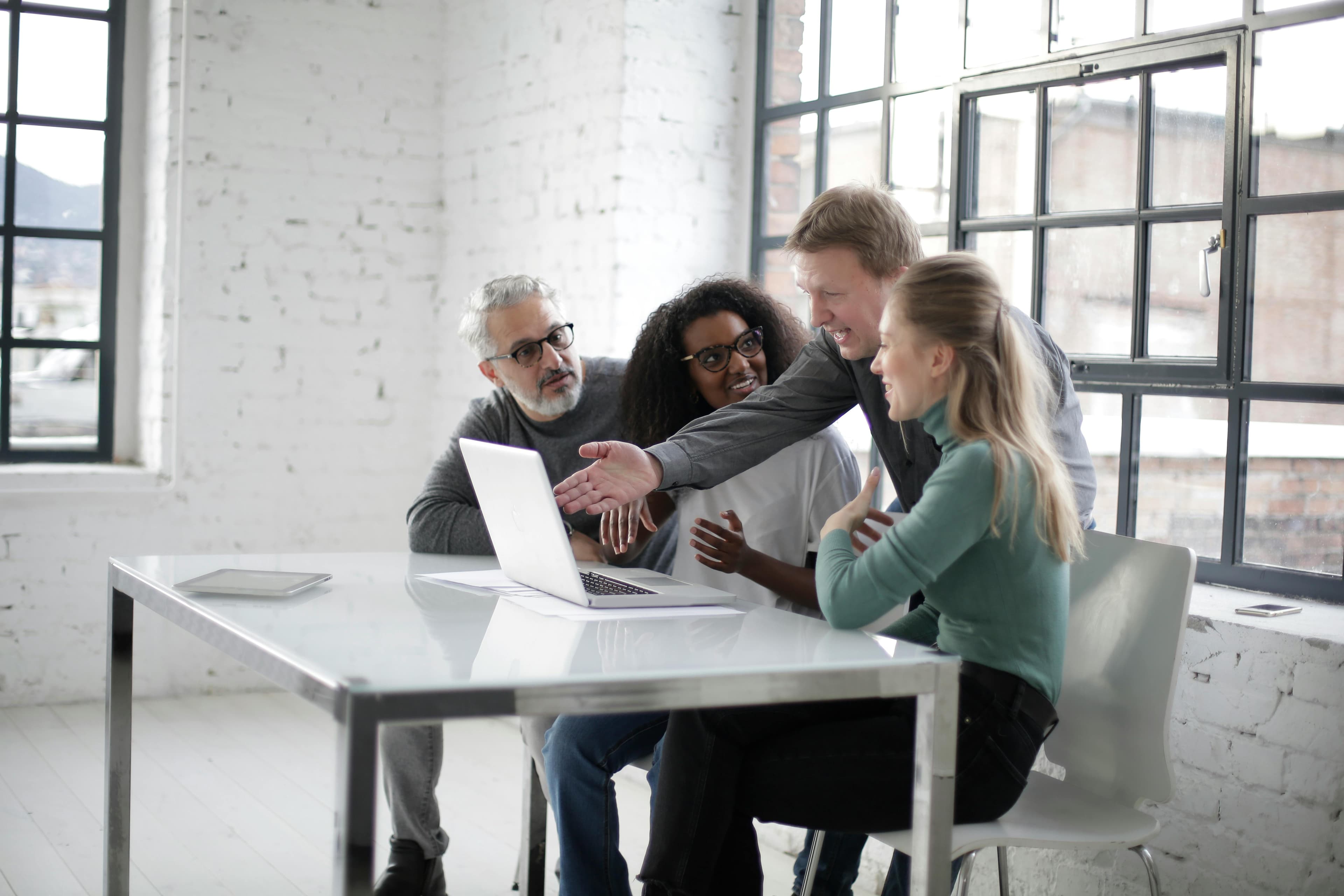 A team having a discussion in front of a computer.